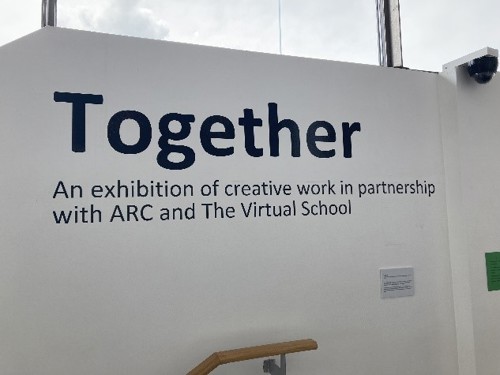 text witten on wall saying "Together - An exhibition of creative work in partnership with ARC and The Virtual School"